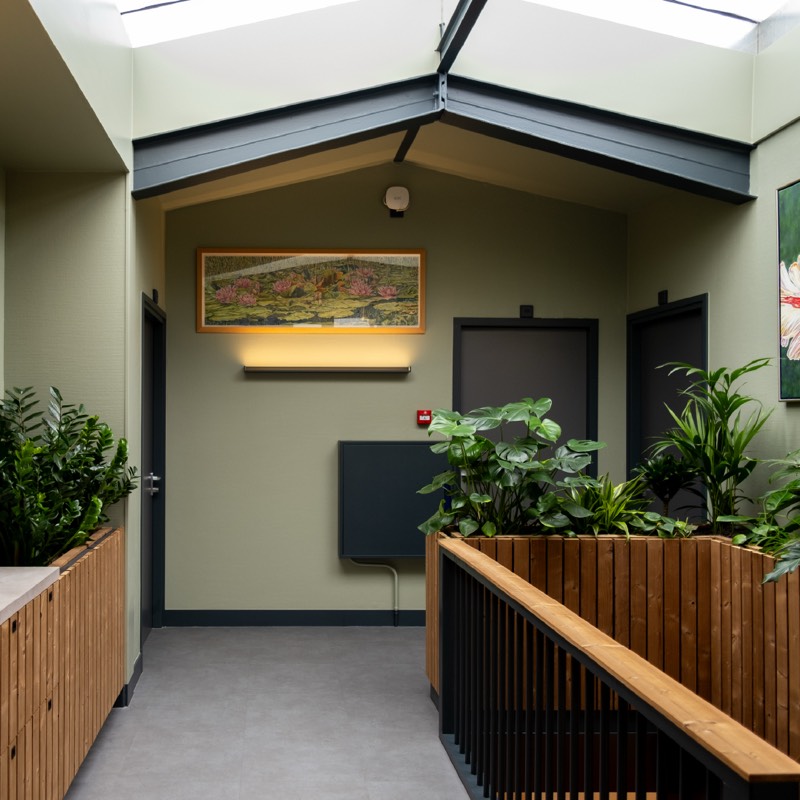 Kantoorinterieur in Heemstede met lichtstraat, groene wanden en houten plantenbakken